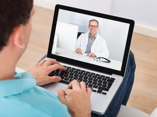 Man having video chat with doctor on a laptop at home
