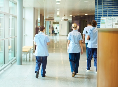 Four nurses walking down a hospital corridor