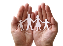 hands holding paper cutout of family