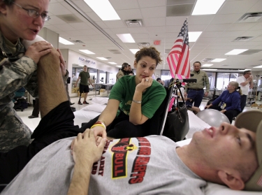 Sgt. John Kriesel receives treatment from a therapist while his wife, Katie, comforts him at the Walter Reed Army Medical Center in Washington, February 9, 2007