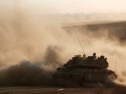An Israeli tank drives near the border as it returns to Israel from Gaza, August 3, 2014