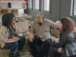 African American female staff member talks with an older couple