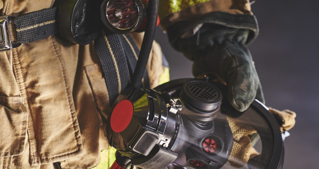 A firefighter holding an oxygen mask