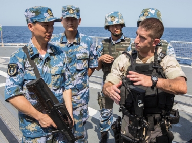 A U.S. gunnery officer discusses techniques with Chinese sailors before a joint counter-piracy exercise in the Gulf of Aden, August 24, 2013