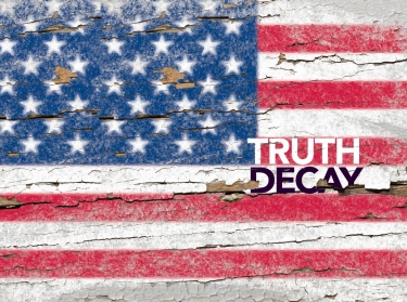 The words Truth Decay over a fading American flag painted on wood