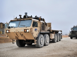 An M1075 palletized load system truck and an M915 line-haul tractor are equipped with add-on kits that transform the vehicles to be fully autonomous, photo by Bruce Huffman/U.S. Army