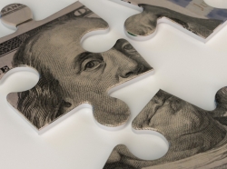 One hundred dollar bill puzzle pieces, photo by gazanfer/Getty Images