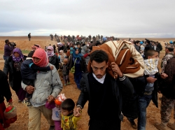 Syrian refugees cross into Jordanian territory, near the town of Ruwaished, 149 miles east of Amman, December 5, 2013, photo by Muhammad Hamed/Reuters