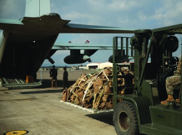 A U.S. Marine with Special Purpose Marine Air-Ground Task Force-Crisis Response-Africa 19.1 loads equipment onto a U.S. Marine Corps KC-130 at Naval Air Station Sigonella, Italy, Dec. 13, 2018. SPMAGTF-CR-AF is deployed to conduct crisis-response and theater-security operations in Europe and Africa, photo by Cpl. Bethanie Ryan/U.S. Marine Corps
