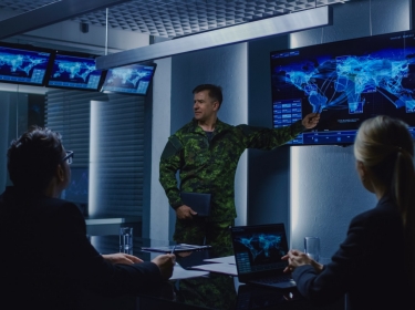 Military leader briefs a team of government officials, photo by Gorodenkoff/Adobe Stock