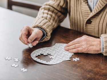 A senior man playing with a puzzle, photo by LightFieldStudios/Getty Images