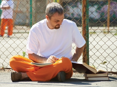 A man studying in prison, photo by mediaphotos/Getty Images