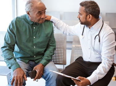 Older gentleman talks with a male doctor, photo by izusek/Getty Images