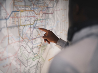 Person pointing at a public transit map, photo by Rawpixel/Getty Images