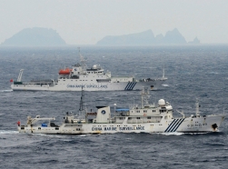 Chinese marine surveillance ships cruising in the East China Sea, as the islands known as the Senkaku isles in Japan and the Diaoyu islands in China are seen in the background, April 23, 2013, photo by Kyodo/Reuters