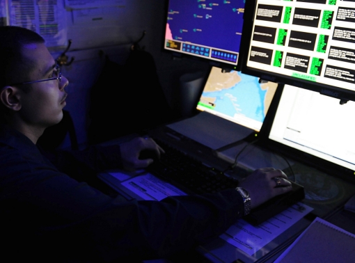 Intelligence specialist monitors automatic identification systems aboard the aircraft carrier USS George H.W. Bush