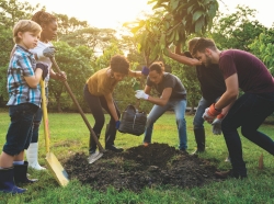 Group of people planting a tree together, photo by Rawpixel/Getty Images