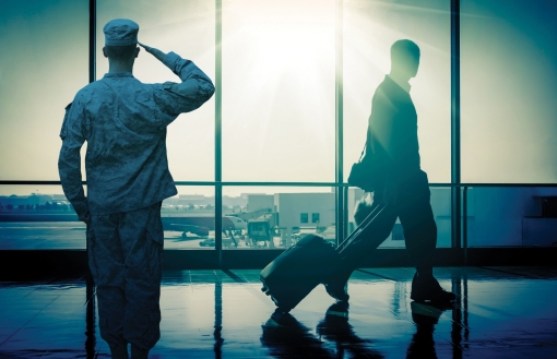 A saluting soldier and a civilian man in an airport