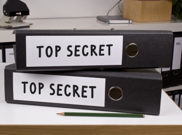 two binders marked top secret on a desk