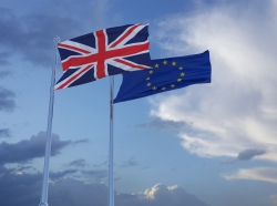 British and European Union flags in a cloudy sky, photo by themotioncloud/Getty Images