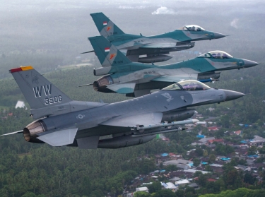 A U.S. Air Force F-16 Fighting Falcon fighter pilot flies alongside two Indonesian air force F-16 Fighting Falcon fighter pilots over the Sam Ratulangi International Airport in Manado, Indonesia