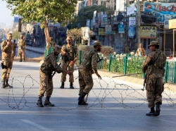 Pakistani soldiers place barbwire to secure a street during a curfew in Rawalpindi