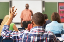 Male student raising hand in class