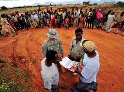 A service member and interpreter talk with residents about malaria prevention in Ethiopia