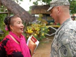 A service member talks with a local official during outreach activities in the Philippines