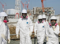 Tokyo Electric Power Company workers stand outside the Fukushima Dai-Ichi nuclear power plant in Japan, February 28, 2012