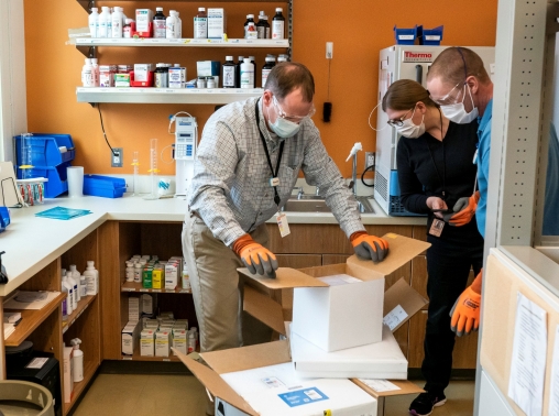 Pharmacists at the Chief Andrew Isaac Health Center unpack a new shipment in Fairbanks, Alaska, March 30, 2021