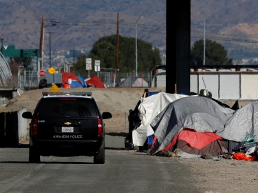 Police continue their patrols as officials begin what they are calling a slow and methodical clean-up and removal of a large homeless encampment along the Santa Ana River Trail in Anaheim, California, January 22, 2018, photo by Mike Blake/Reuters