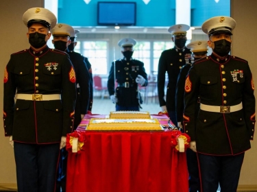 Marines with Marine Corps Recruiting Command march in the cake for the 246th Marine Corps birthday at the Clubs of Quantico, Virginia, November 4, 2021, photo by Lance Cpl. Jennifer Sanchez/U.S. Marine Corps