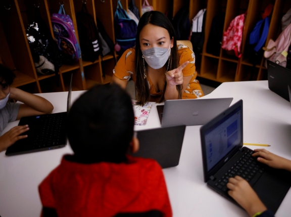 Teacher Mary Yi works with fourth-grade students at the Sokolowski School in Chelsea, Massachusetts, September 15, 2021, photo by Brian Snyder/Reuters