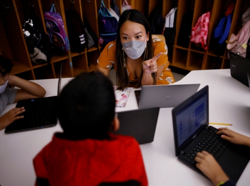 Teacher Mary Yi works with fourth-grade students at the Sokolowski School in Chelsea, Massachusetts, September 15, 2021