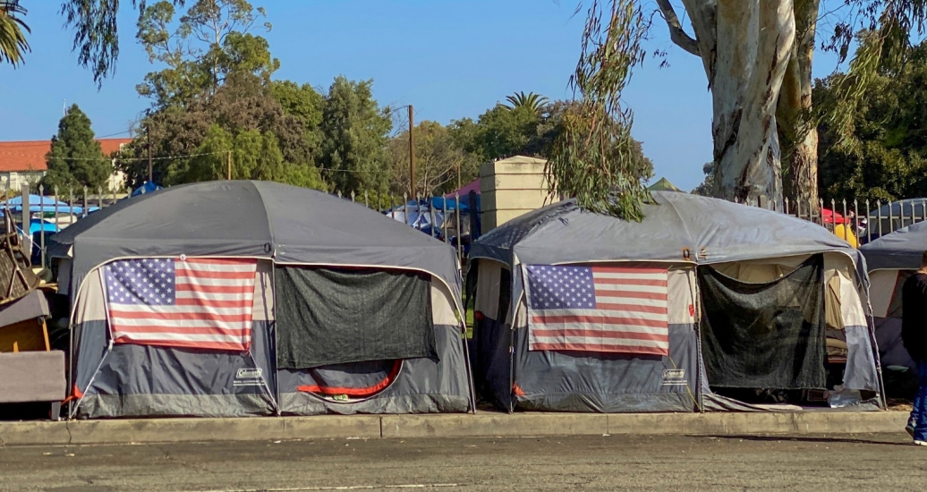 Encampment of tents with American flags in Los Angeles, photo by Bethany/Adobe Stock