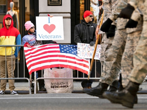 Spectators hold signs supporting veterans along the 2018 Veterans Day Parade route in New York City, November 11, 2018