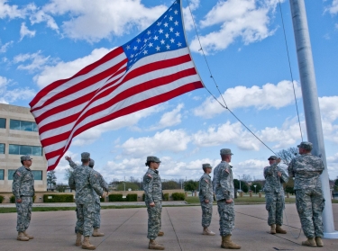 A formation of U.S. Army soldiers with III Corps and Fort Hood honor the American flag as they lower it during the Retreat ceremony, March 27, 2014, photo by U.S. Army