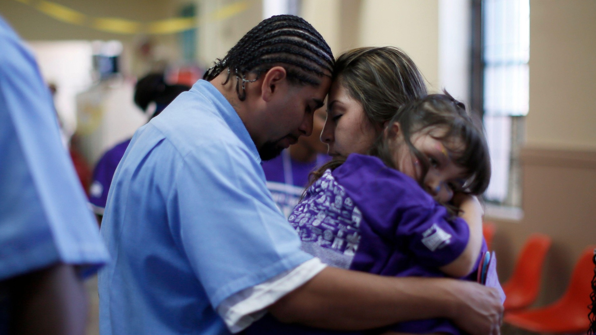 A woman says goodbye to her partner as she holds their 5-year-old daughter at San Quentin state prison, June 8, 2012