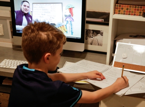 A student watches his teacher's lesson on a computer at home, Seattle, Washington, March 27, 2020