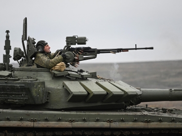 A tank crew member of the Russian armed forces fires a weapon during combat drills at the Kadamovsky range in the Rostov region, Russia, December 14, 2021, photo by Sergey Pivovarov/Reuters