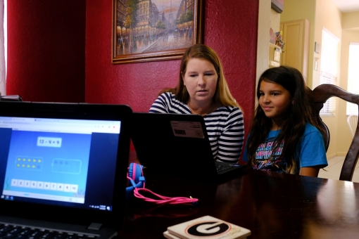 Jennifer Panditaratne helps Hazeline with her reading assignments as she is homeschooling in Broward County, Florida, U.S. May 29, 2020. Picture taken May 29, 2020