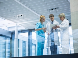Medical staff talking in a hospital corridor, photo by Wavebreakmedia/Getty Images