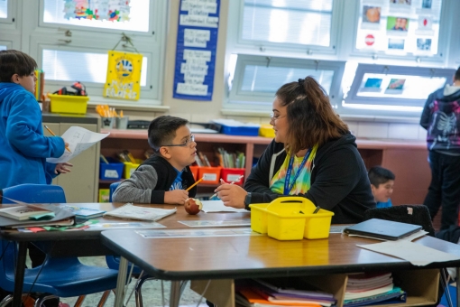 A teacher and student talking in a classroom