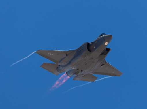 F-35 Lightning II  approaching  with afterburner on and condensation trails at the wings tip
