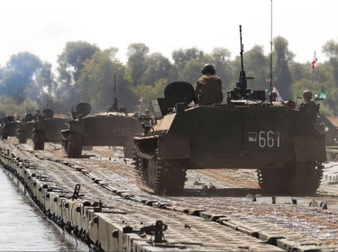 Military vehicles cross a floating pontoon bridge built over the Oka River as part of a joint military exercise held in Murom, Russia, July 28, 2021, photo by Alexander Ryumin/TASS/Alamy