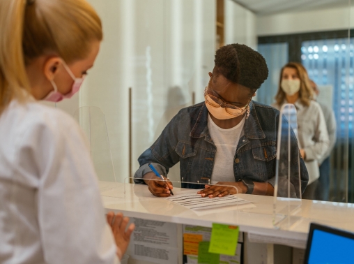 A patient at a medical clinic filling out paperwork