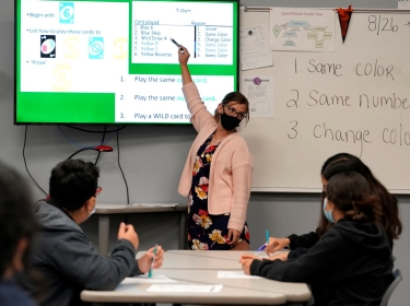 A teacher works with students in a math class while wearing a mask to prevent the spread of COVID-19 at Santa Fe South High School in Oklahoma City, Oklahoma, September 1, 2021, photo by Nick Oxford/Reuters