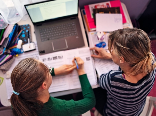 A mother helping her teenager with schoolwork