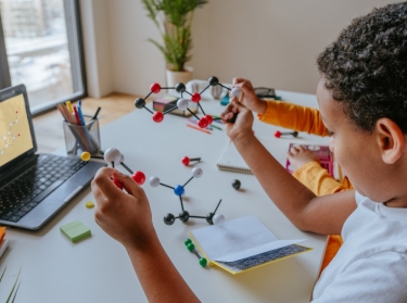 Student puts together molecular model during online school. lesson, photo by lithiumphoto/Adobe Stock